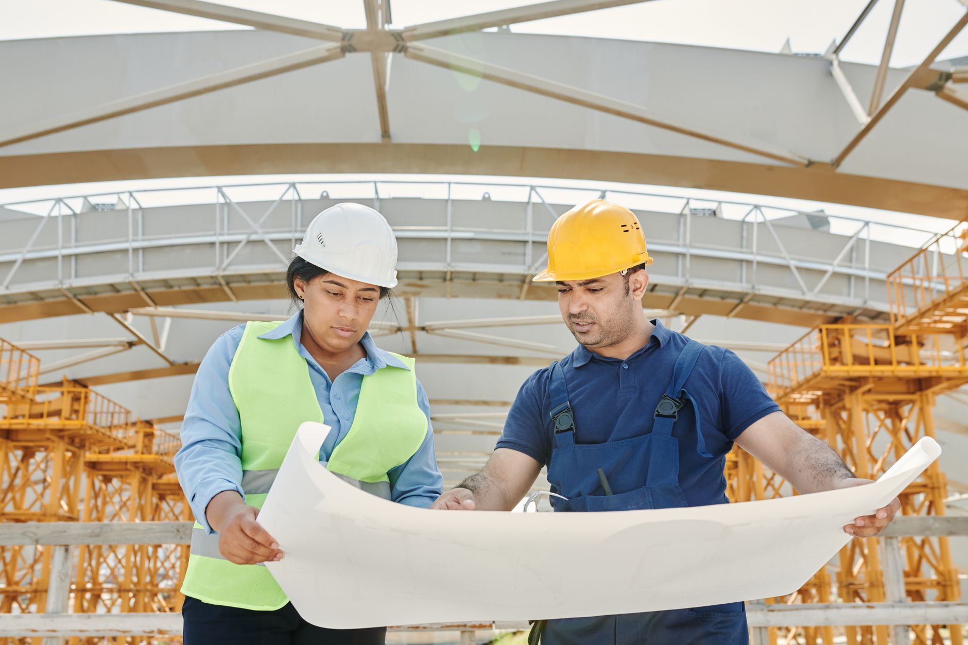 Workers in high visibility clothing and safety helmets reviewing a task on site
